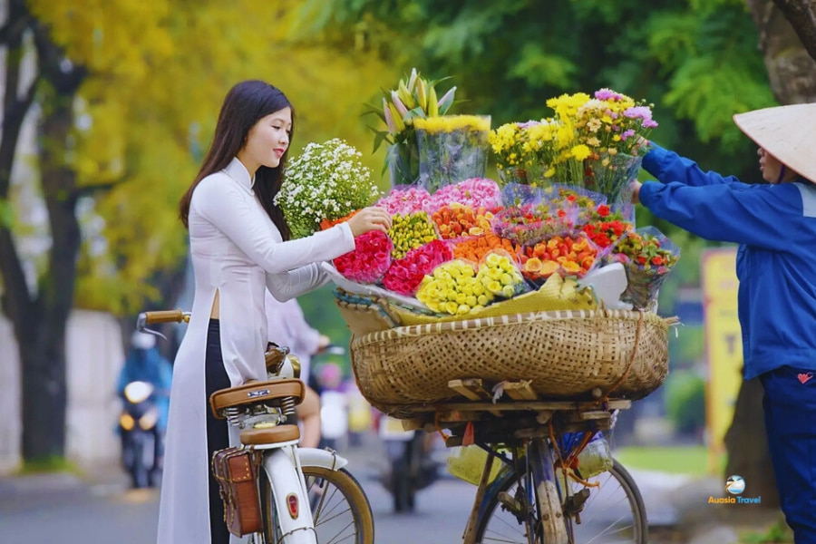 Vietnamese girl choosing flowers at Hanoi street market – Auasia Travel